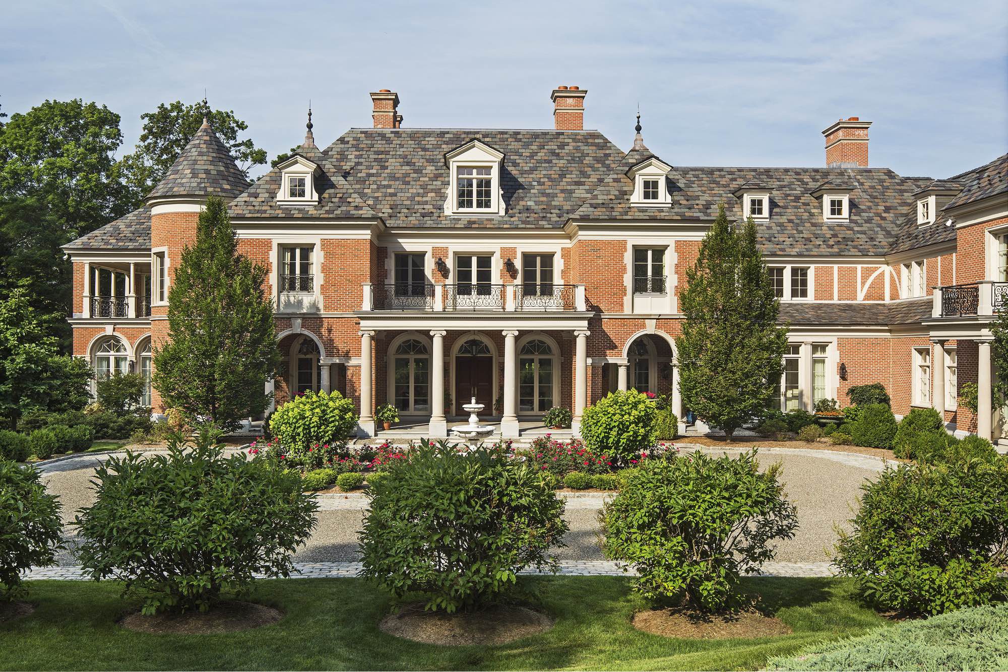 Inspired by the brick and limestone buildings of seventeenth-century Paris, particularly around the Place des Vosges, the house is composed of classical details juxtaposed with steep slate roofs and brick that suggest an earlier time.