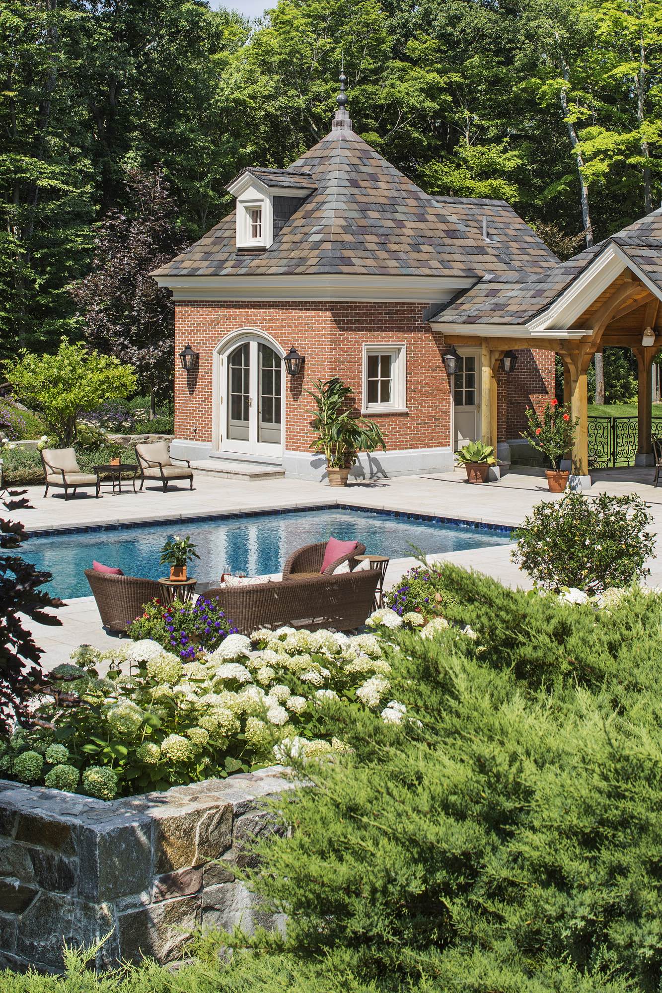 The pool, pool house, and timber-framed pavilion are located on a lower level of the property.