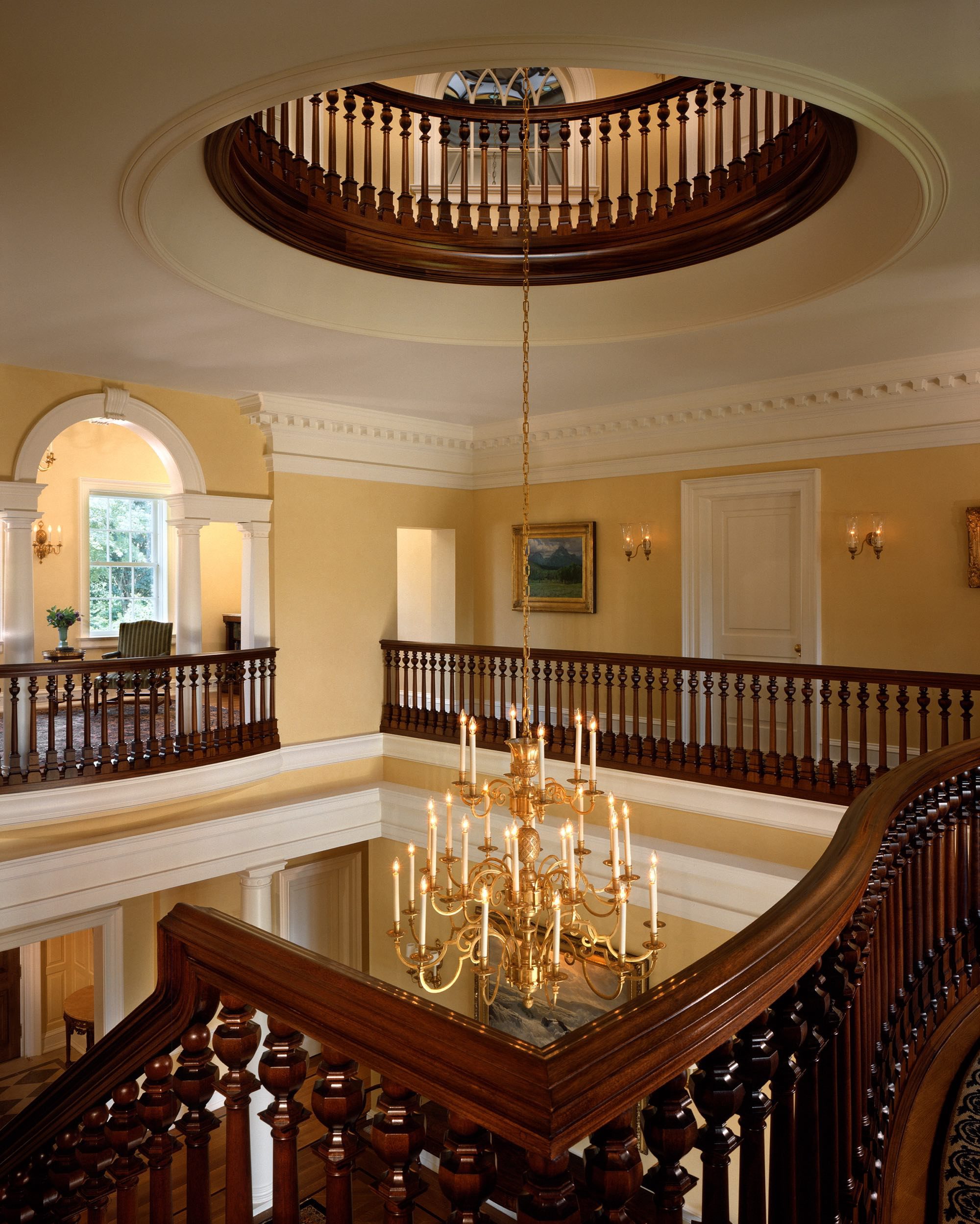 Top of the staircase with a clear view of a chandelier